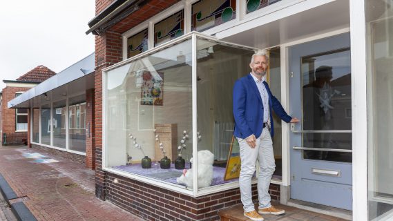 Wethouder Bé Schollema bij de deur van de duurzame demowoning in Middelds