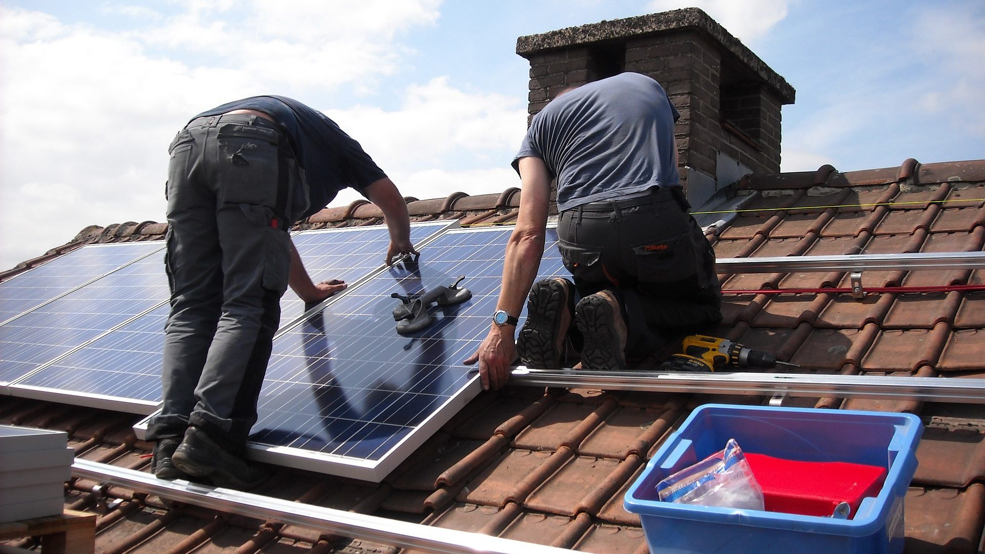 Sfeerbeeld van installateurs die zonnepanelen op een dak monteren.