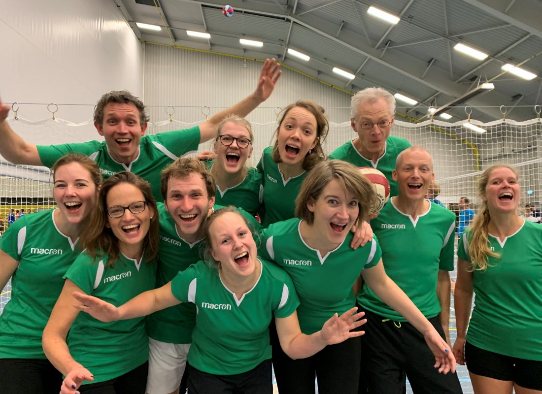 Team Nationaal Programma Groningen in groene sportshirts tijdens een volleybalwedstrijd.