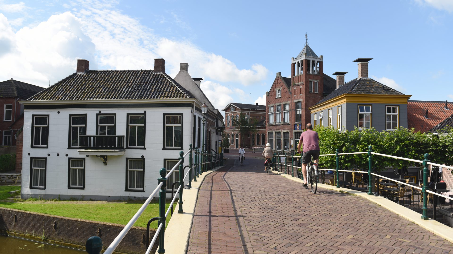 Fietsers over een bruggetje in Winsum, een dorp in de gemeente Het Hogeland.