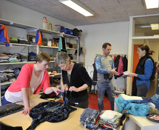 Sfeerbeeld van een bewonersinitiatief, mensen die kleding ruilen in de ruilwinkel het Heerdenhoes in Beijum.