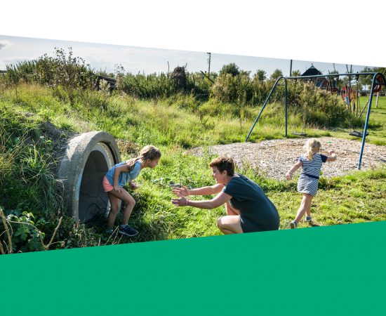 Sfeerbeeld van een moeder met twee kinderen in de speeltuin. Opgemaakt in de stijl van het jaarverslag