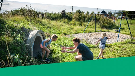 Sfeerbeeld van een moeder met twee kinderen in de speeltuin. Opgemaakt in de stijl van het jaarverslag