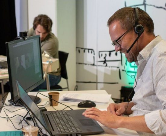 Lachende gespreksleider is aan het beeldbellen met zijn groep tijdens Toukomst bundelsessies