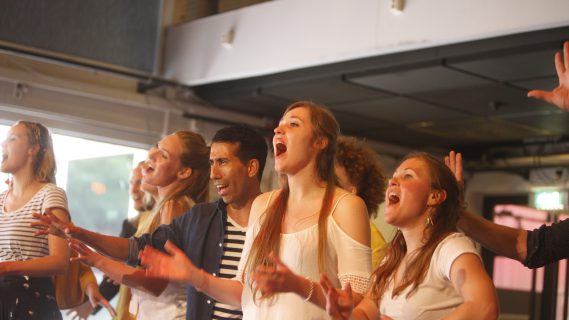 Sfeerbeeld van een koor dat uitbundig zingt.