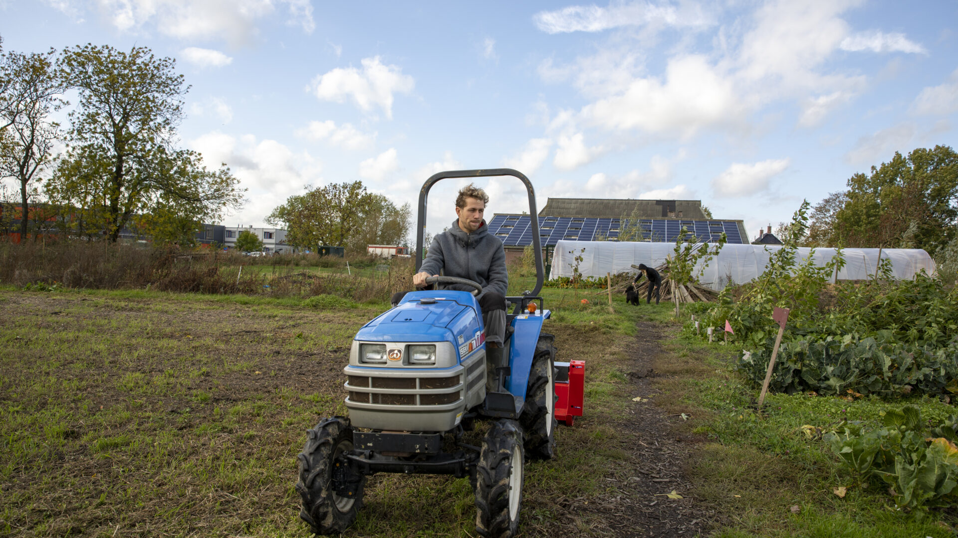 Arjan de Witte op zijn trekker in de zelfsoogsttuin in Ten Boer.