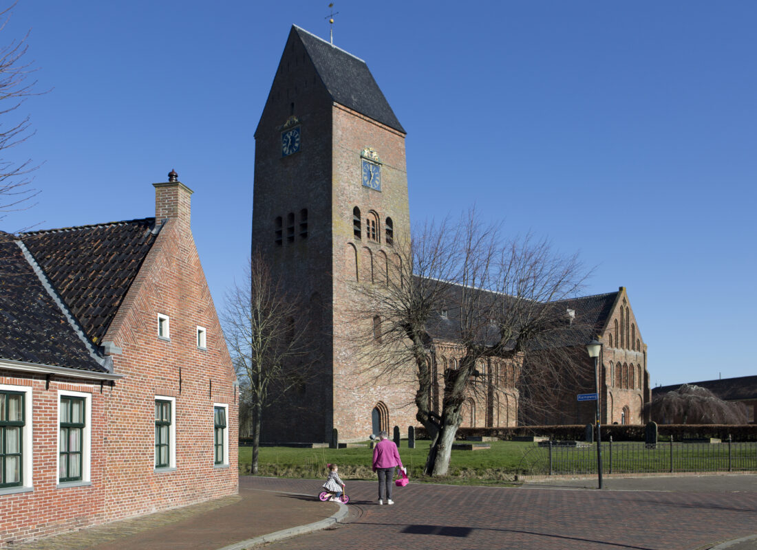 Decoratieve afbeelding van een oma die met haar kleinkind voor de kerk in Zeerijp langsloopt
