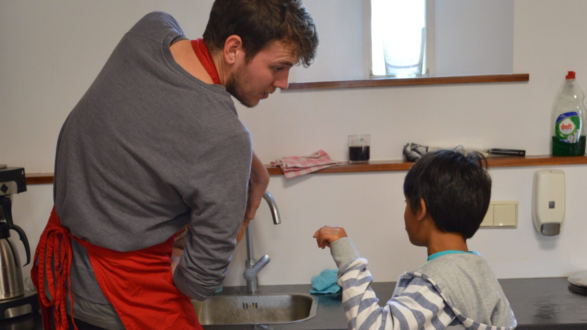 Decoratieve afbeelding van een man die een kind aan het helpen is in de keuken