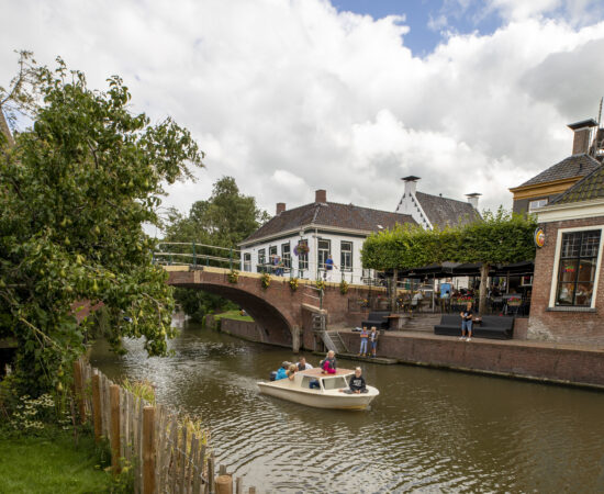 Decoratieve afbeelding van kinderen varend in een bootje in Winsum