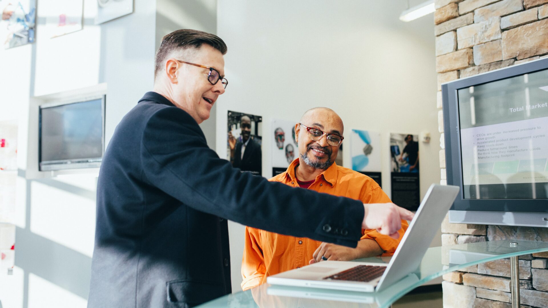 Decoratieve afbeelding van een leidinggevende die een werknemer iets laat zien op een computer