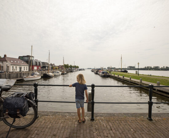 Decoratieve foto van een jongetje die uitkijkt vanaf een brug in Zoutkamp