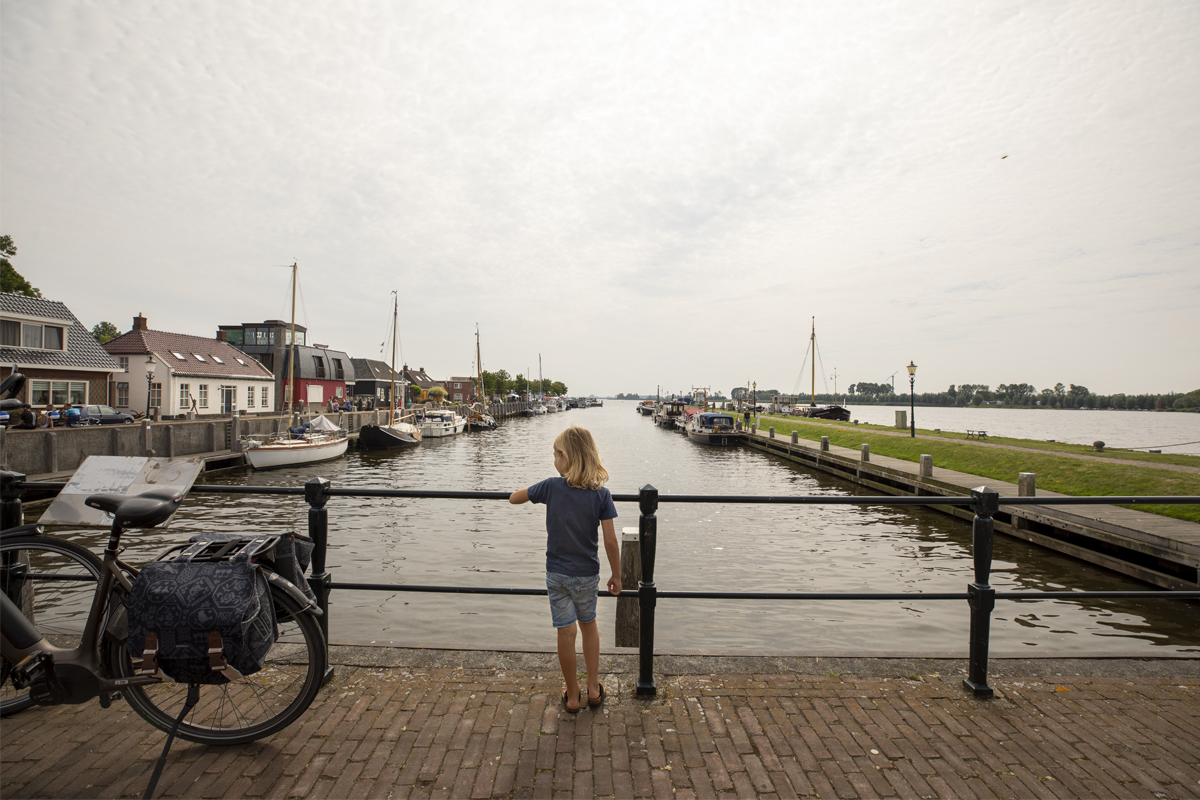 Decoratieve foto van een jongetje die uitkijkt vanaf een brug in Zoutkamp