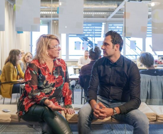 Decoratieve afbeelding van een man en een vrouw die samen op een bankje iets aan het overleggen zijn