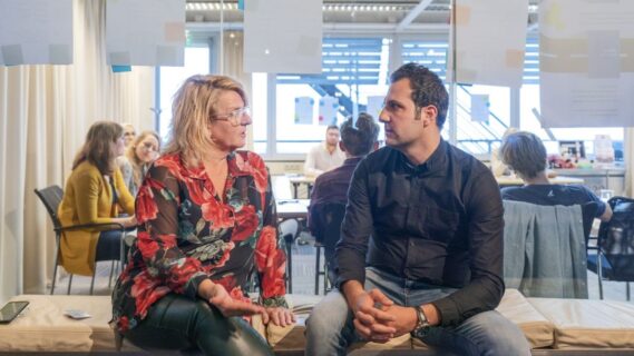 Decoratieve afbeelding van een man en een vrouw die samen op een bankje iets aan het overleggen zijn
