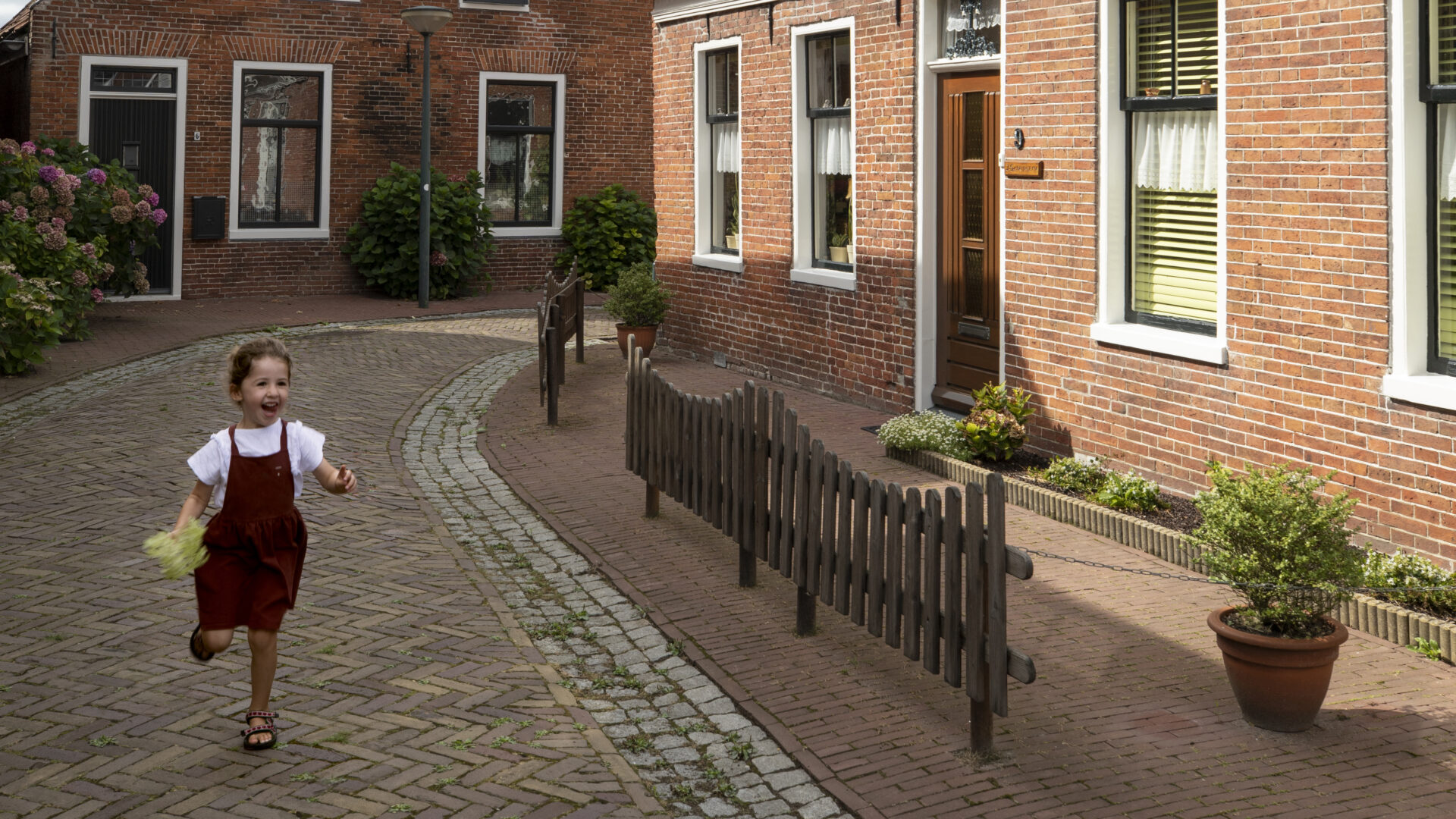 Decoratieve afbeelding van een klein meisje die door de straten van Winsum rent