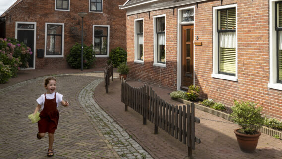Decoratieve afbeelding van een klein meisje die door de straten van Winsum rent