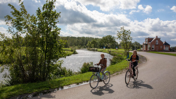 Decoratieve afbeelding van twee scholieren op de fiets in Winneweer