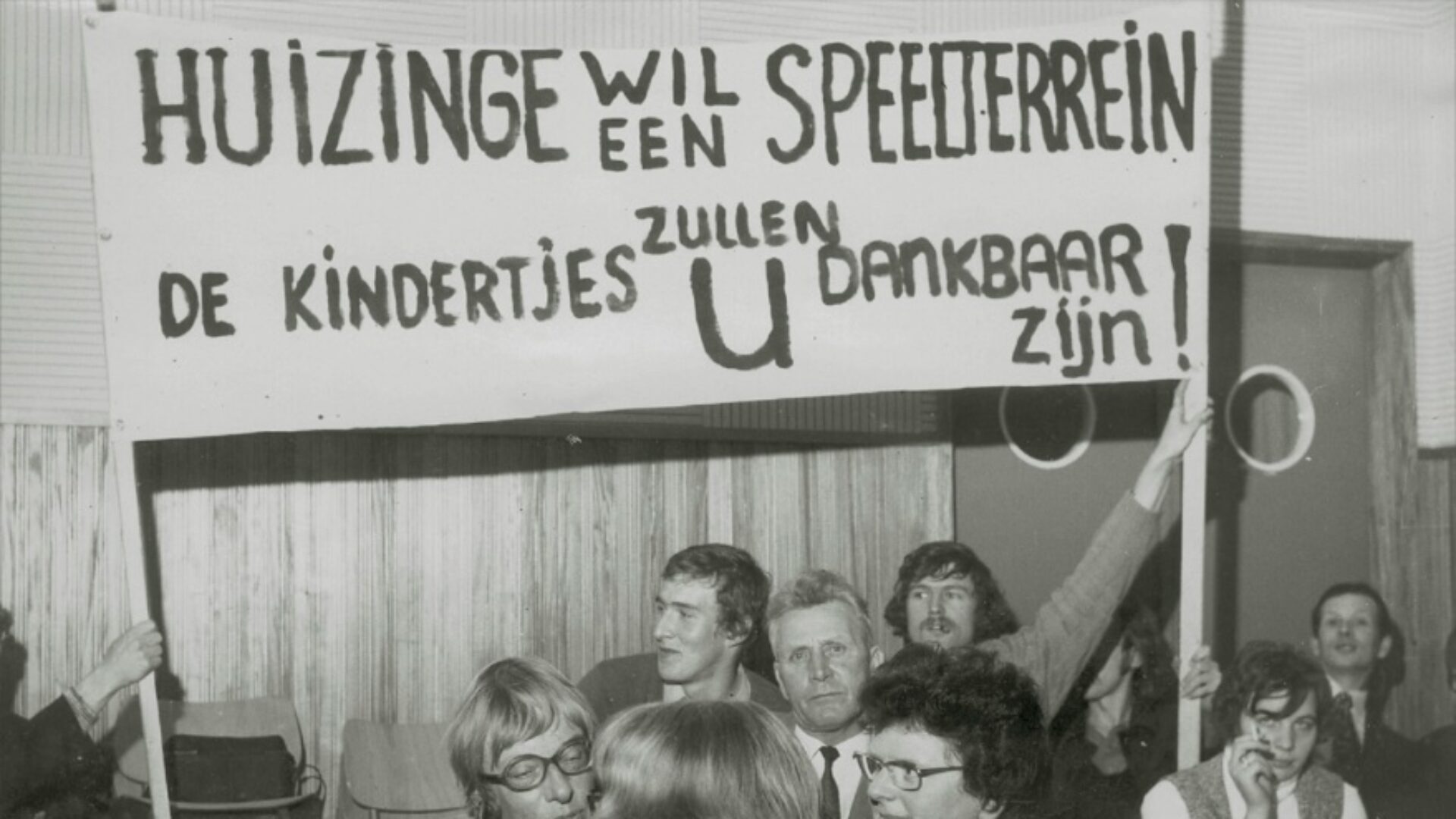 Decoratieve foto uit 1974 waarin bewoners oproepen tot een nieuw speelterrein voor de kinderen met een spandoek