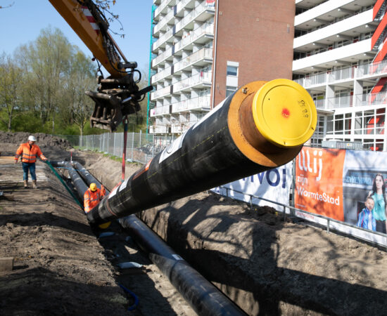 Decoratieve foto van buizen die in de grond worden gezet door WarmteStad