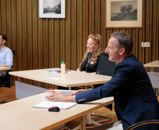 Decoratieve afbeelding van Rene Donkerbroek die luistert naar een presentatie van een trainee