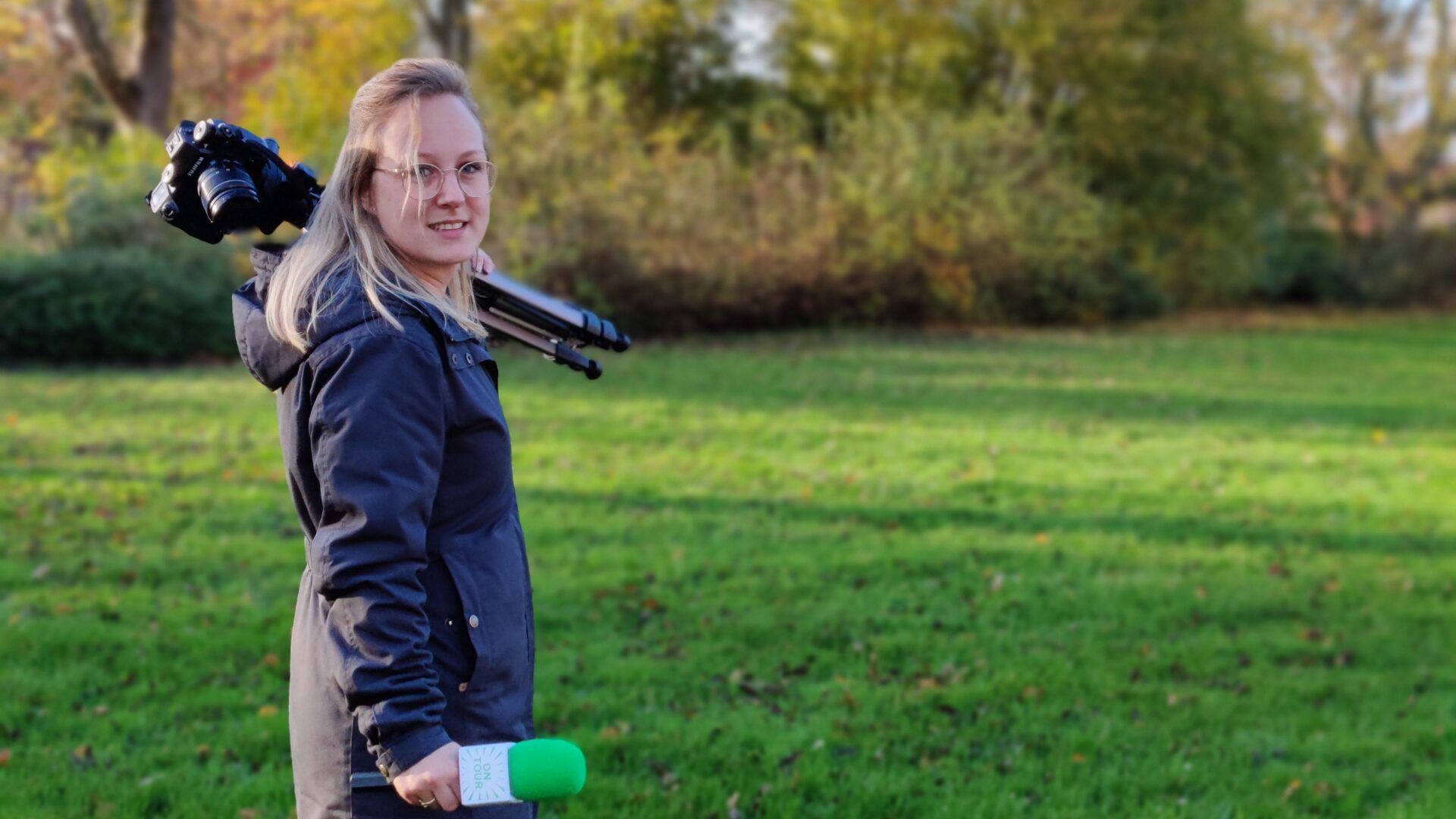 Portretfoto van Sandra Dijkstra met camera en microfoon in haar hand