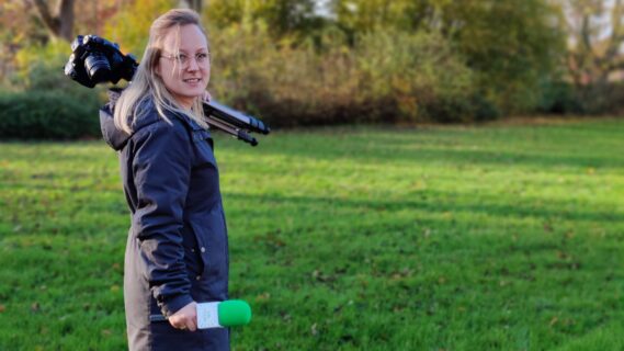 Portretfoto van Sandra Dijkstra met camera en microfoon in haar hand