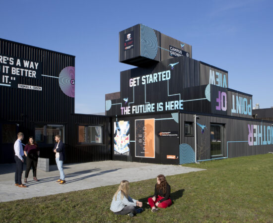 Studenten zitten op de grond voor een schoolgebouw