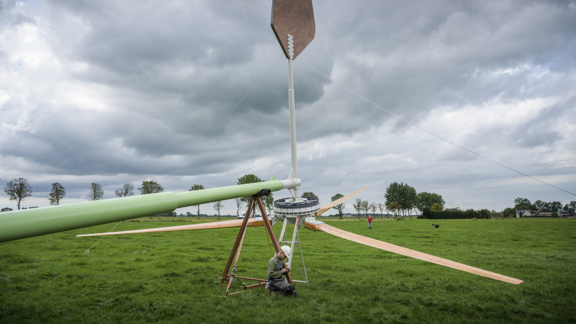 Man pleegt onderhoudt aan windmolen.