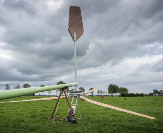 Man pleegt onderhoudt aan windmolen.